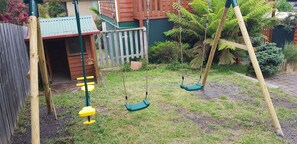 Ein Spielplatz mit Schaukeln und Klettergerüsten.