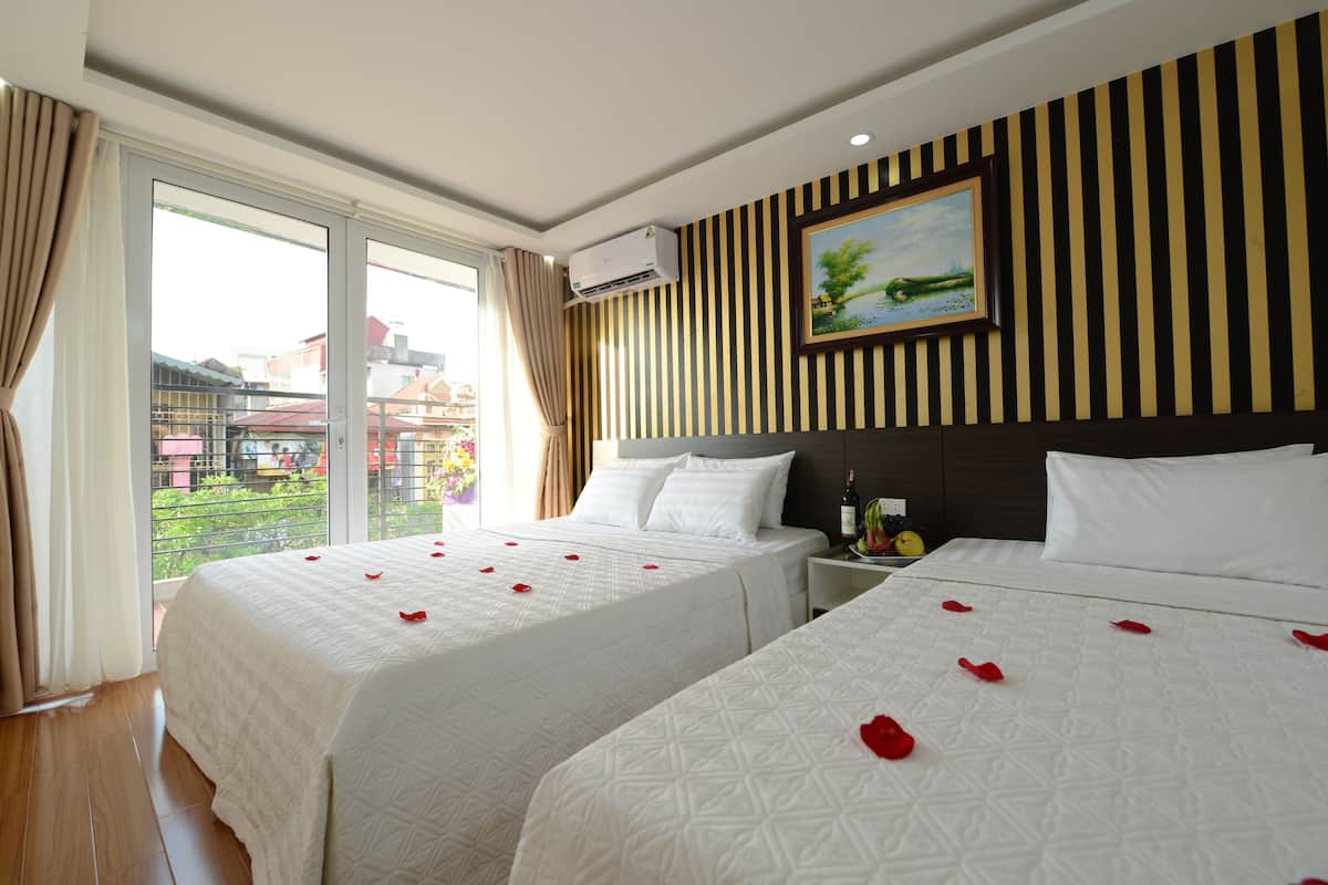 Ein Hotelzimmer mit zwei Betten, einem großen Fenster und einem Gemälde an der Wand.