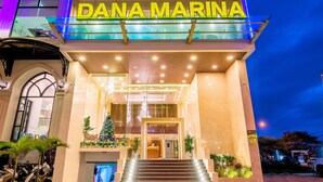 The exterior of Dana Marina hotel with a prominent entrance, steps leading up to the door, and a Christmas tree decoration.