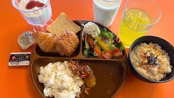 A meal with rice, salad, croissants, and drinks on a tray.