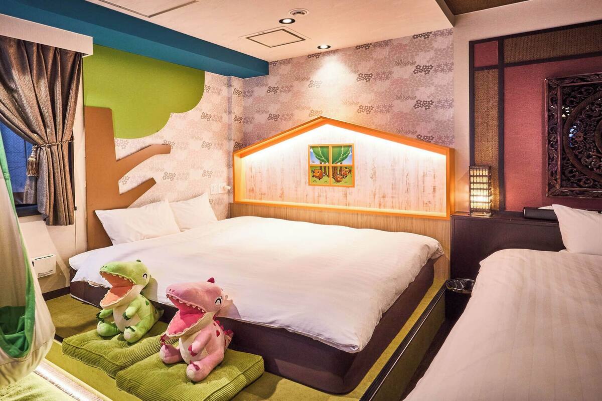 A hotel room with a bed, a hanging chair, and a wall with a decorative panel.