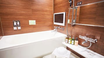 Een moderne badkamer met een witte badkuip, een digitale spiegel en een douchegedeelte.