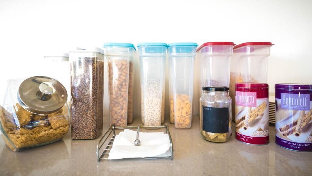 Various food storage containers with lids on a countertop.
