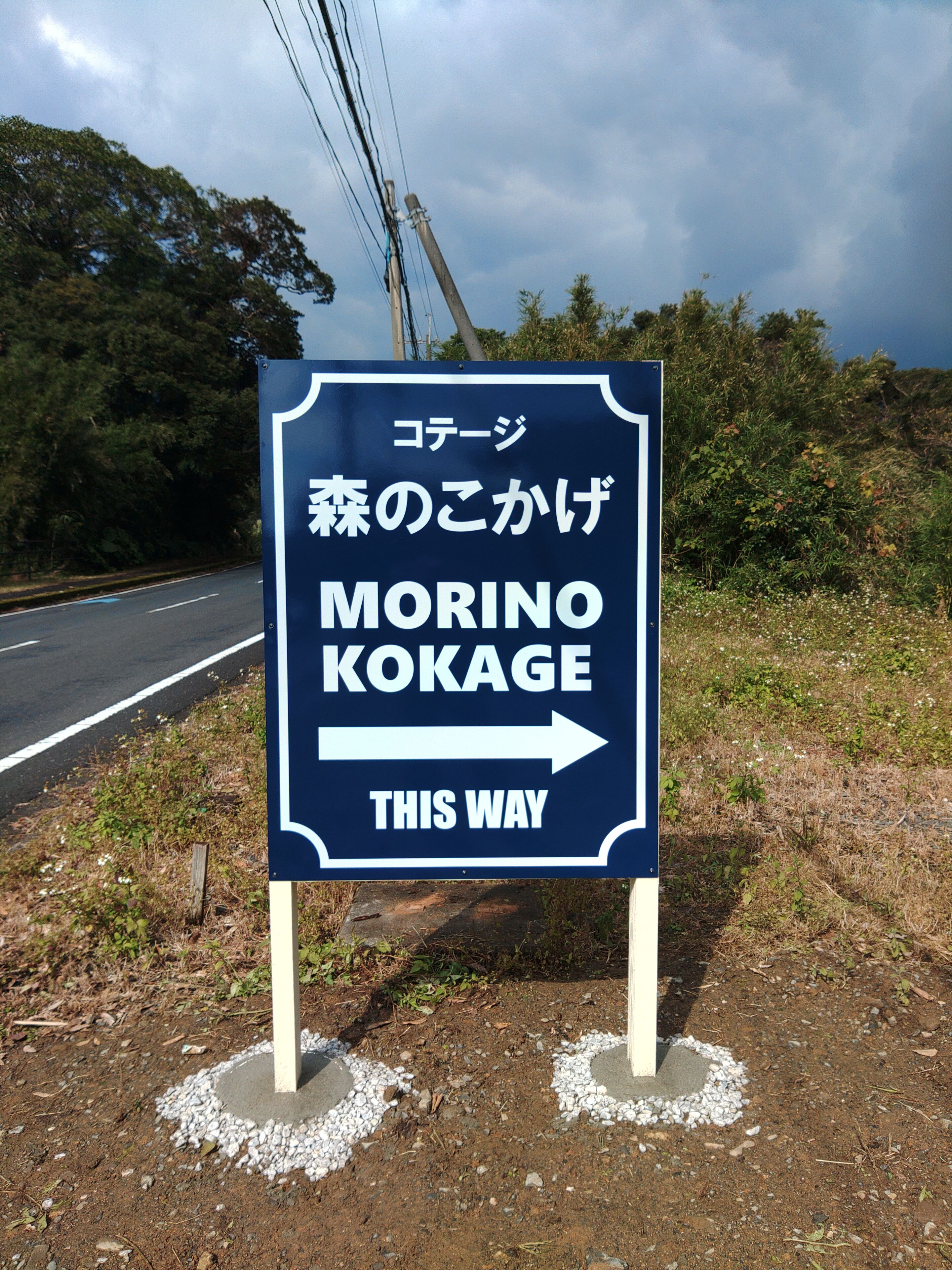 A directional sign with Japanese text and an arrow pointing right, indicating the way to Morino Kokage.