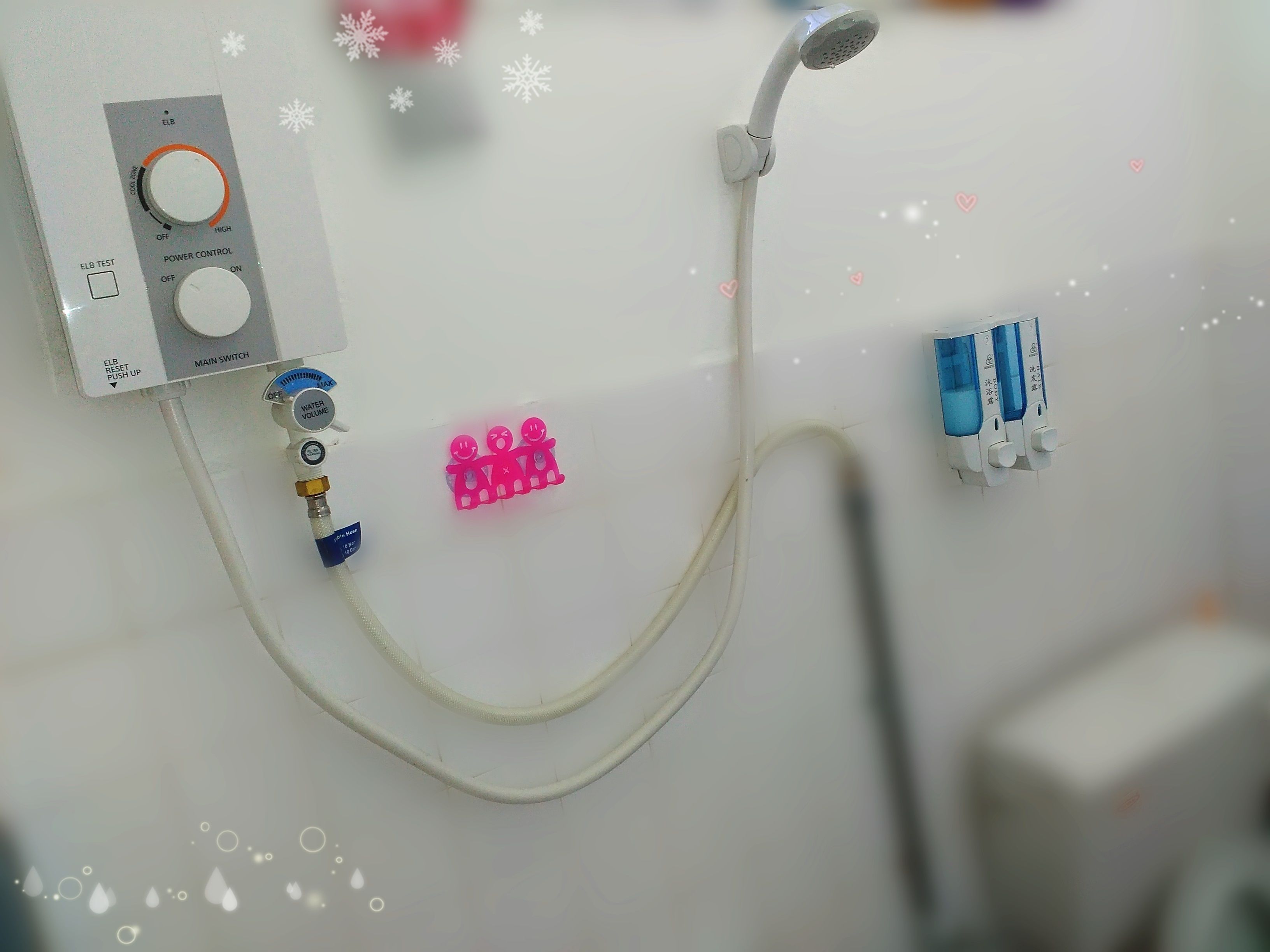 A bathroom with a shower control panel, a handheld showerhead, and a water valve.