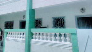 A multi-story building with white exterior walls and green trim. - Résidence Belle Vue (Abidjan)