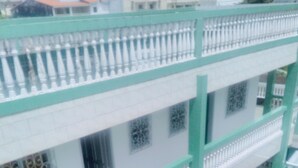 A multi-story building with balconies, a tiled ground floor, and a patterned window design. - Résidence Belle Vue (Abidjan)