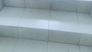 A set of white tiled stairs leading upwards, with a handrail on the left. - Résidence Belle Vue (Abidjan)