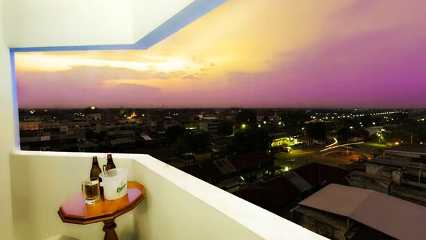 A balcony with a view of a cityscape at dusk.