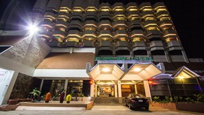 A Rose Inn Hotel with a modern architectural design, featuring a prominent entrance with steps and a car parked in front.