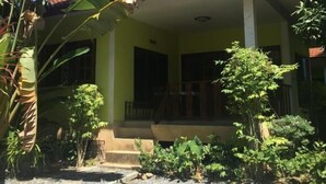 A house with a tiled roof, a porch, and a garden with various plants. - Baan Promjan (Koh Samui)