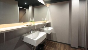 A modern bathroom with two sinks, a large mirror, and a wooden floor. - Hotel Zipang (Osaka)