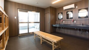 A modern bathroom with a bench, multiple sinks, and mirrors.