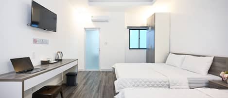 Una habitación de hotel moderna con escritorio, computadora portátil y cama.