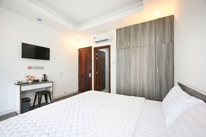 A hotel room with a bed, a desk, a TV, and a wardrobe. - Yoko Airport Saigon Hotel (Ho Chi Minh City)