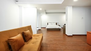 A modern hotel room with a large bed, a sofa, and a small desk. - Yoko Airport Saigon Hotel (Ho Chi Minh City)