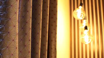 A close-up of patterned curtains and hanging light bulbs.
