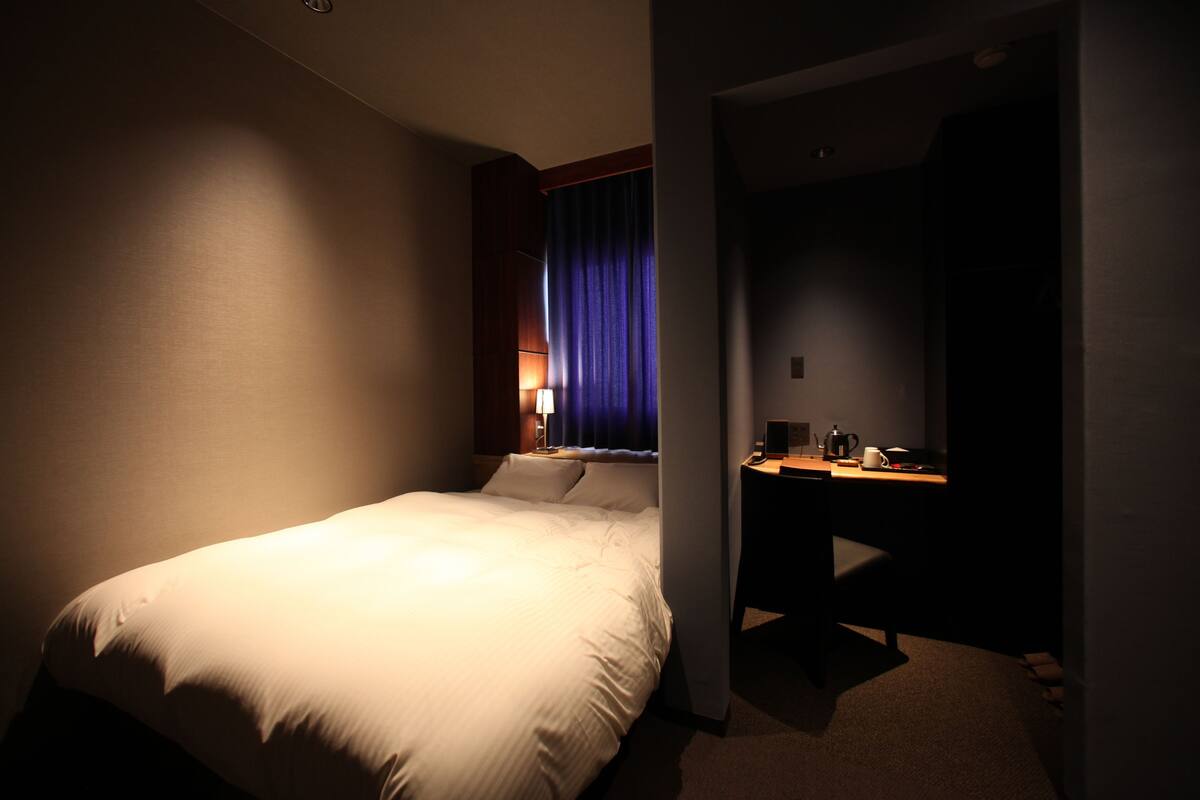 Une chambre d’hôtel avec un grand lit, un bureau et une chaise.