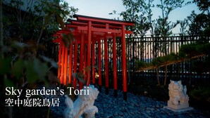 A red torii gate in a garden setting. - Hot Spring OSAKA HINODE HOTEL NIPPONBASHI (Osaka)