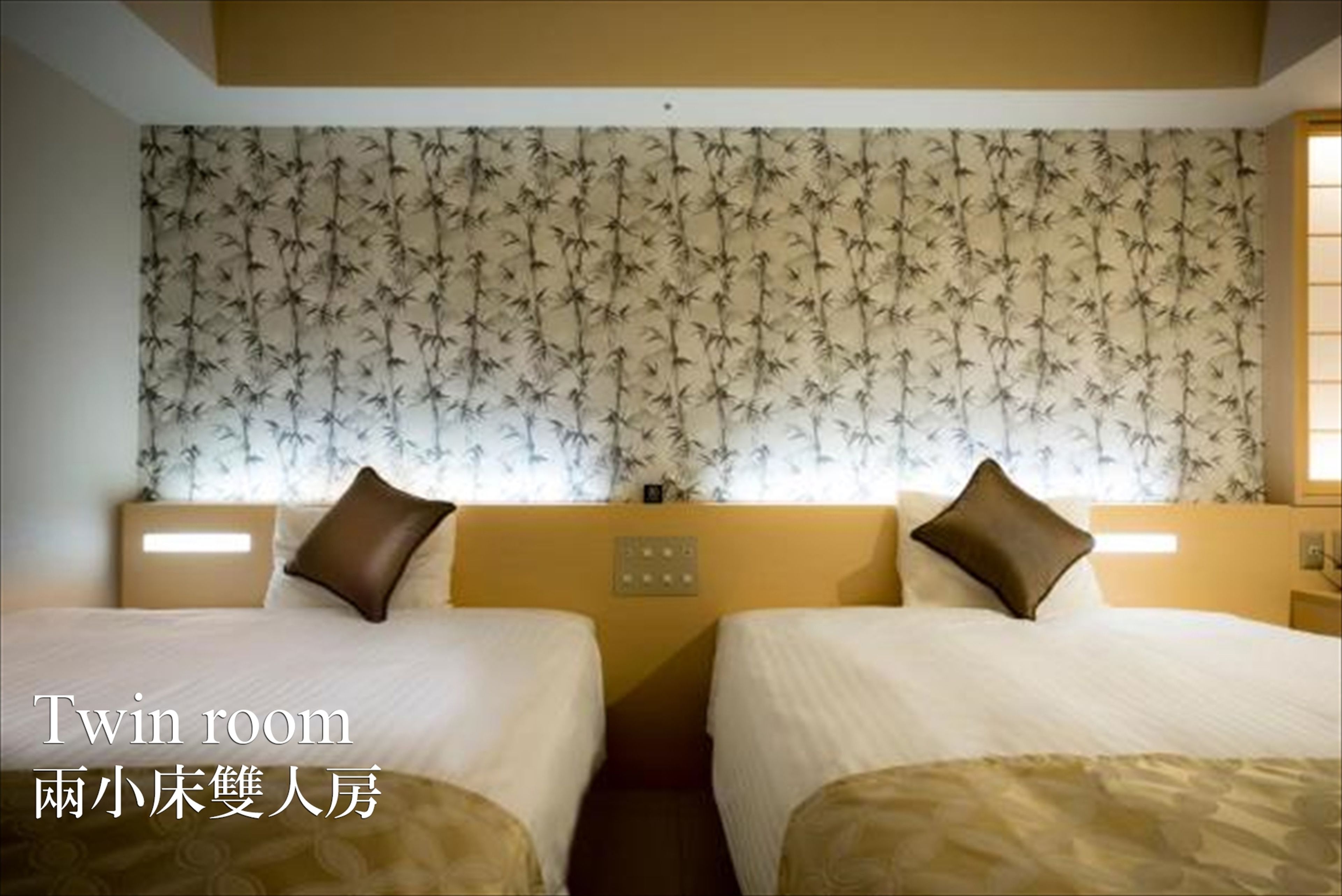 Une chambre double avec deux lits, un papier peint à motifs et des lampes de chevet.