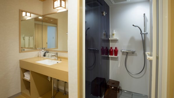 A bathroom with a sink, mirror, and shower. - Hot Spring OSAKA HINODE HOTEL NIPPONBASHI (Osaka)