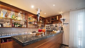 A bar area with shelves of liquor bottles, glasses, and a granite countertop. - Hotel Nuova Flavia (Lignano Sabbiadoro)