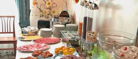 A buffet table with various food items and a decorative wall.