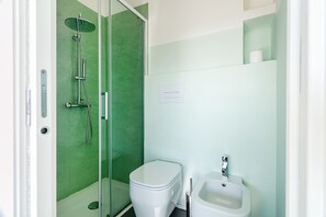 A modern bathroom with a glass-enclosed shower, a white toilet, and a pedestal sink. - Sardegna è - Villa Charme&Design (Olbia)