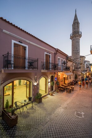 A historic street with a prominent tower, outdoor seating, and traditional architecture.