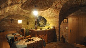 Un comedor rústico con paredes de ladrillo, mesas de madera y una zona de bar central con un barril.