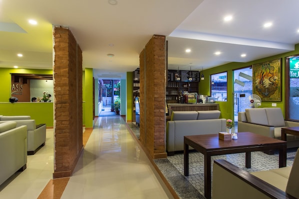 A hotel lobby with a central seating area, a reception desk, and a bar area. - Oasis Kathmandu Hotel (Kathmandu)