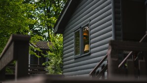 A wooden cabin with a window, a staircase, and a view of trees. - Lusty Beg Island (Enniskillen)