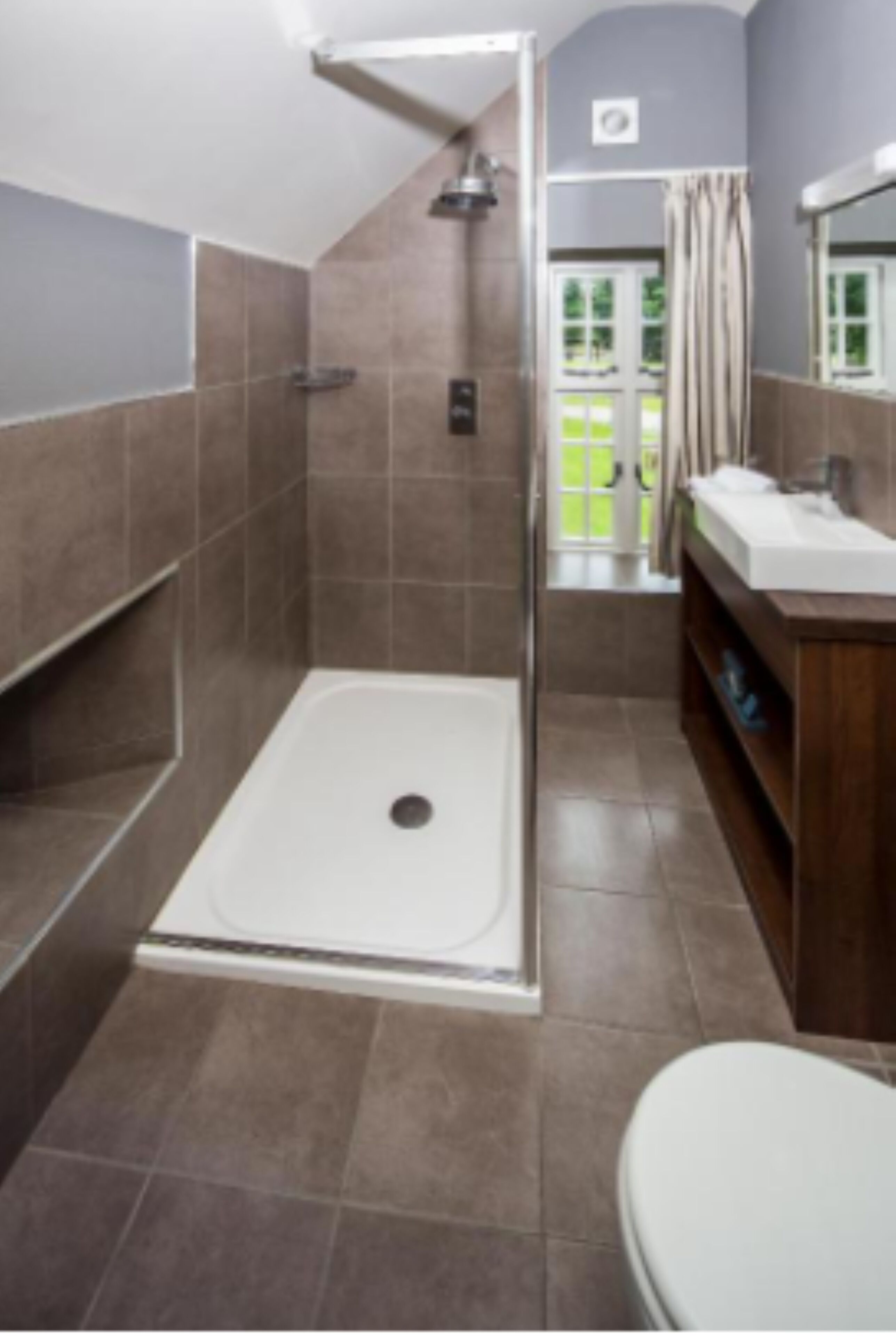 Un baño moderno con ducha, inodoro y lavabo.
