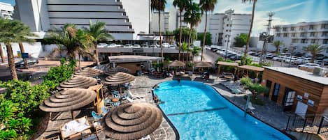 Una piscina al aire libre, sillones reclinables de piscina