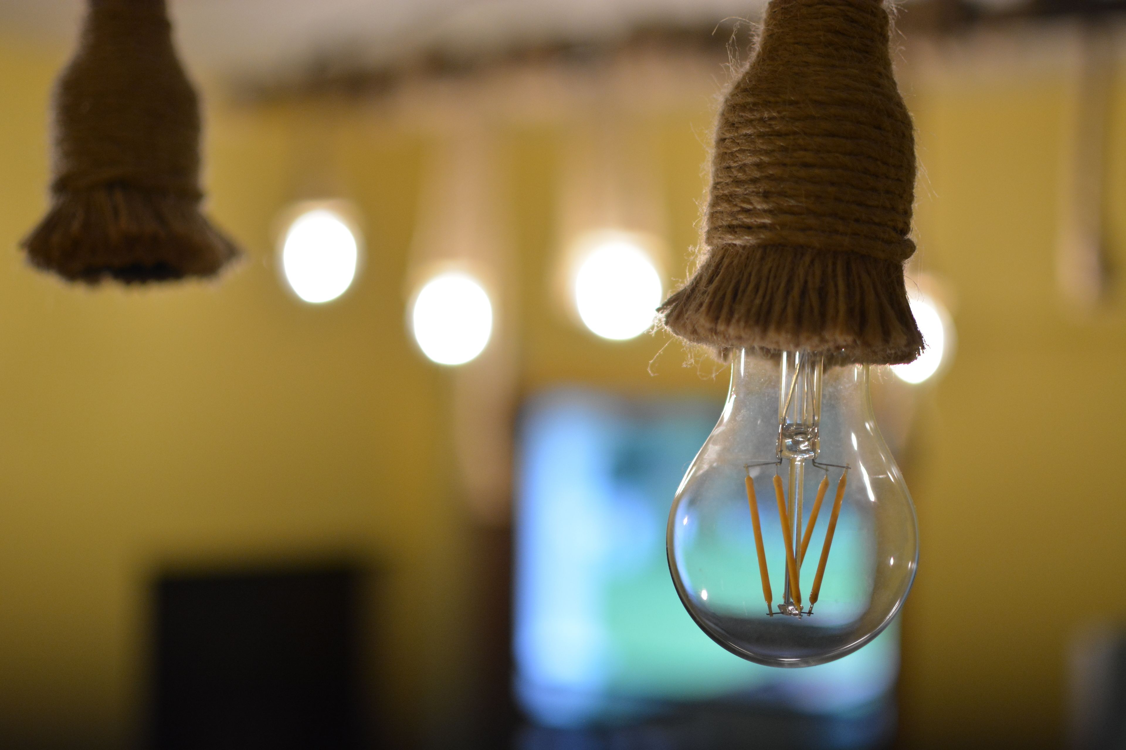 Une ampoule, entourée d’une corde, suspendue au plafond.