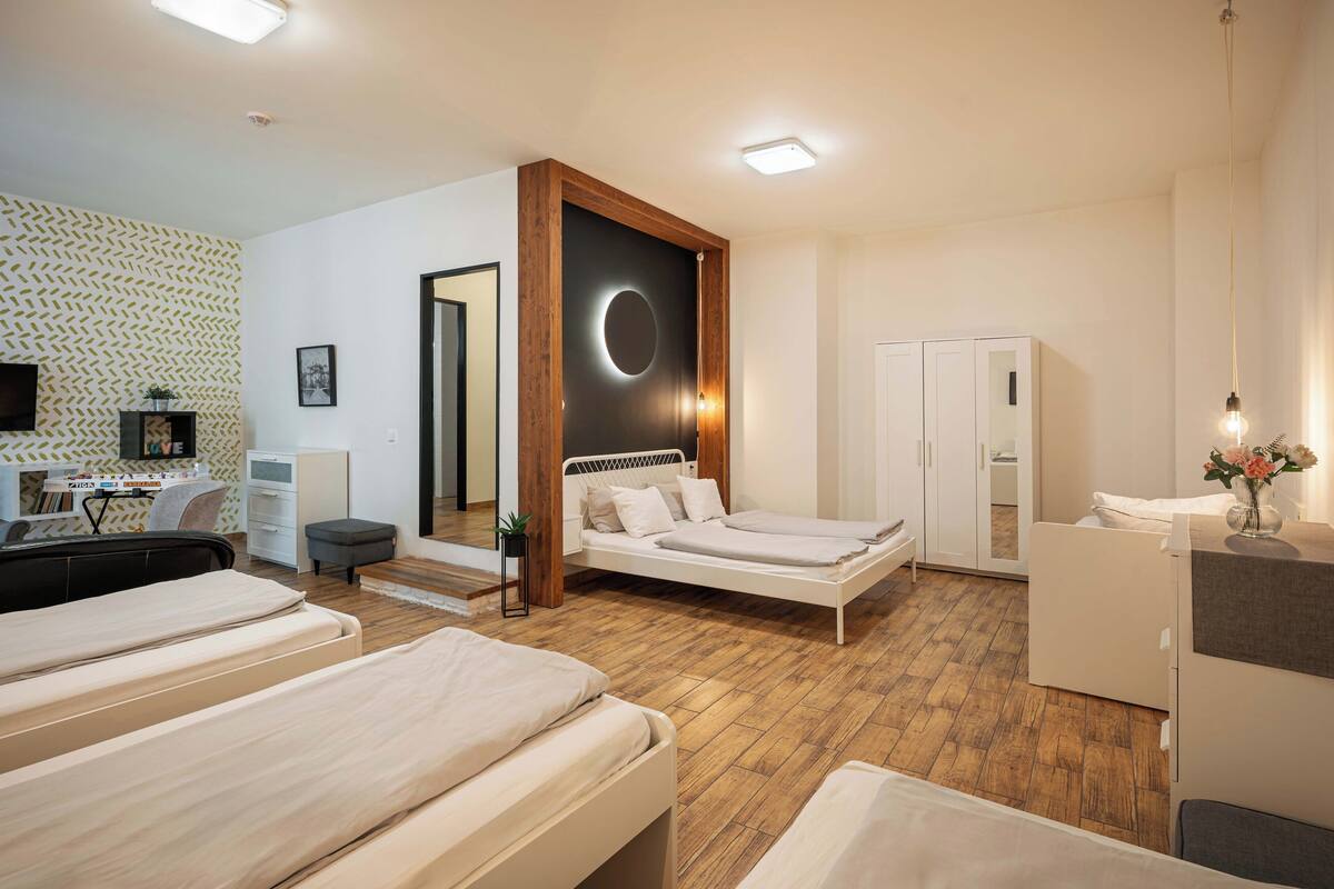 A modern hotel room with a bed, a desk, and a wardrobe.