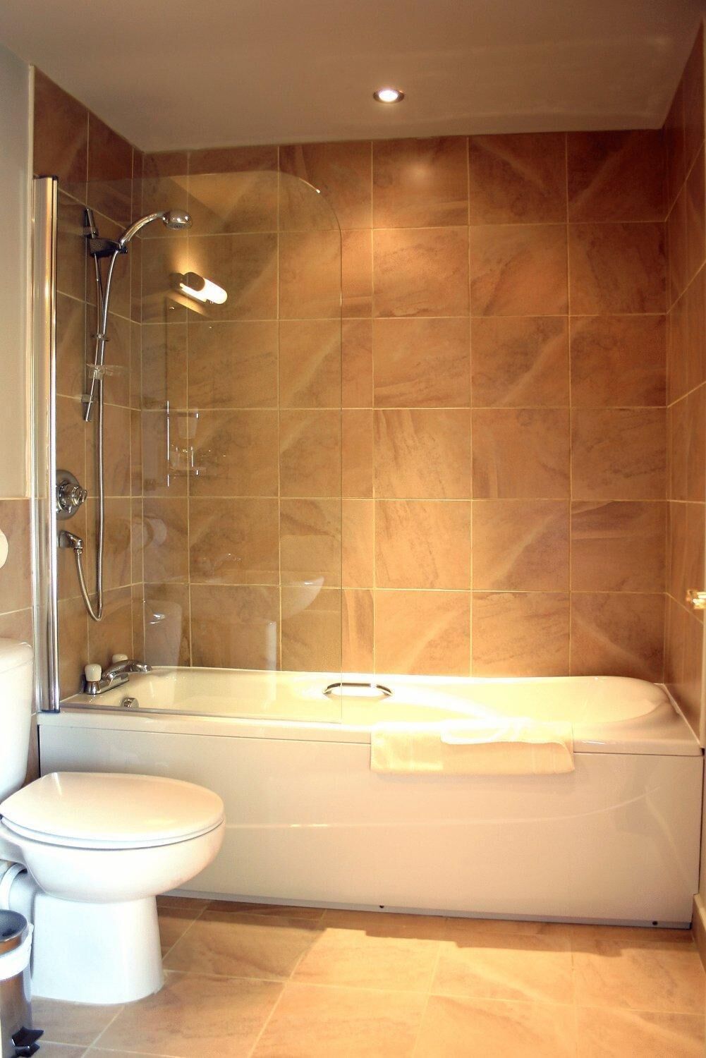 A bathroom with a bathtub, shower, and toilet.