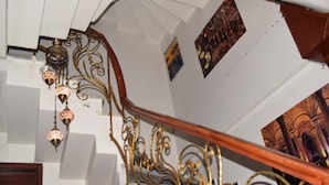 Una escalera con barandillas de metal ornamentadas y una barandilla de madera.