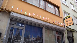 Un hotel con un letrero que dice 'Royal Suites' y varias banderas a la vista.