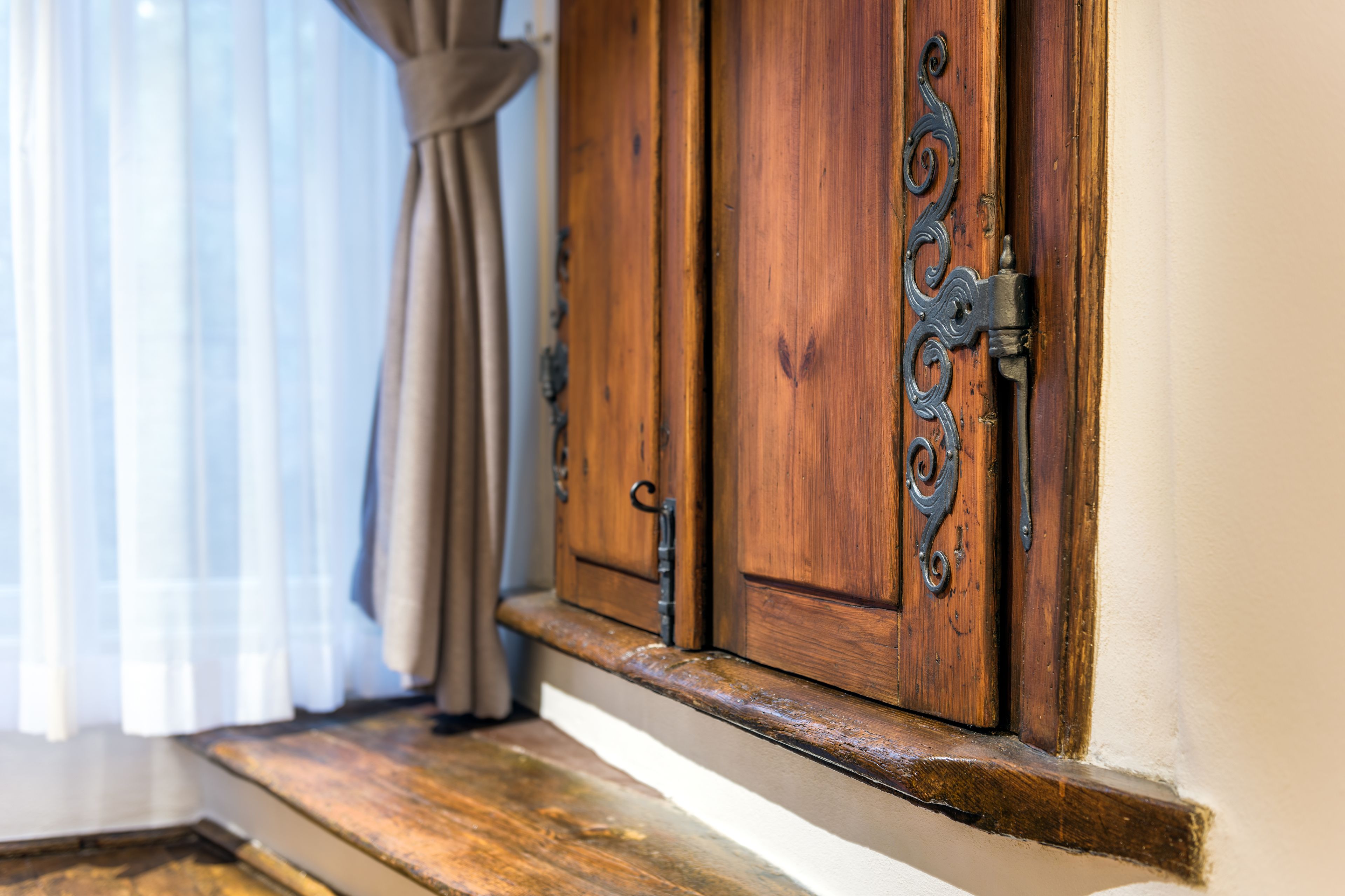 Une porte en bois avec un loquet en métal et une poignée décorative en métal.