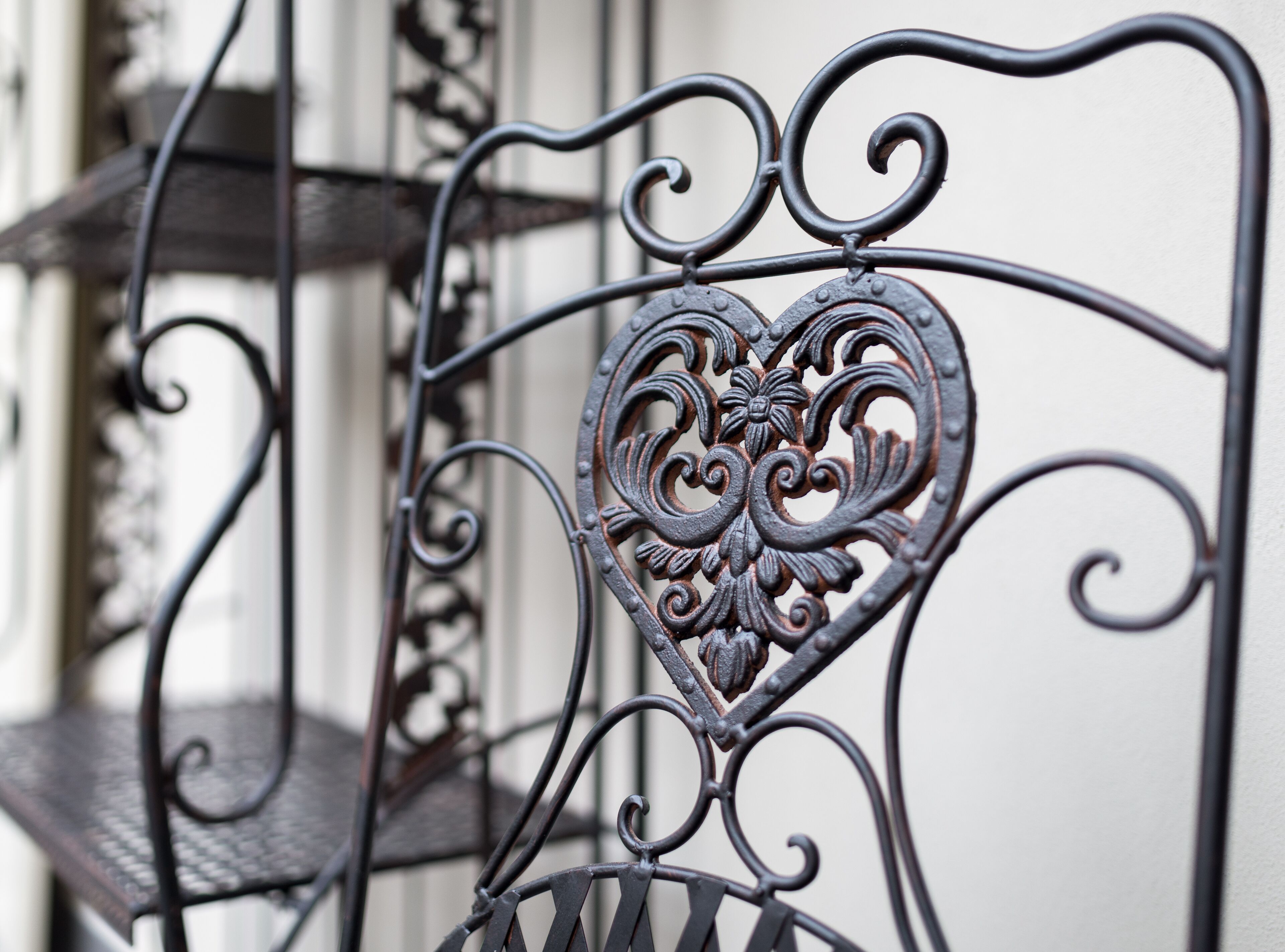 A wrought iron balcony railing with a heart-shaped design.