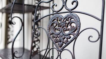A wrought iron balcony railing with a heart-shaped design.