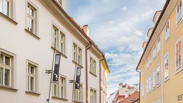 A cobblestone street with historic buildings, a pub sign, and a clear sky.