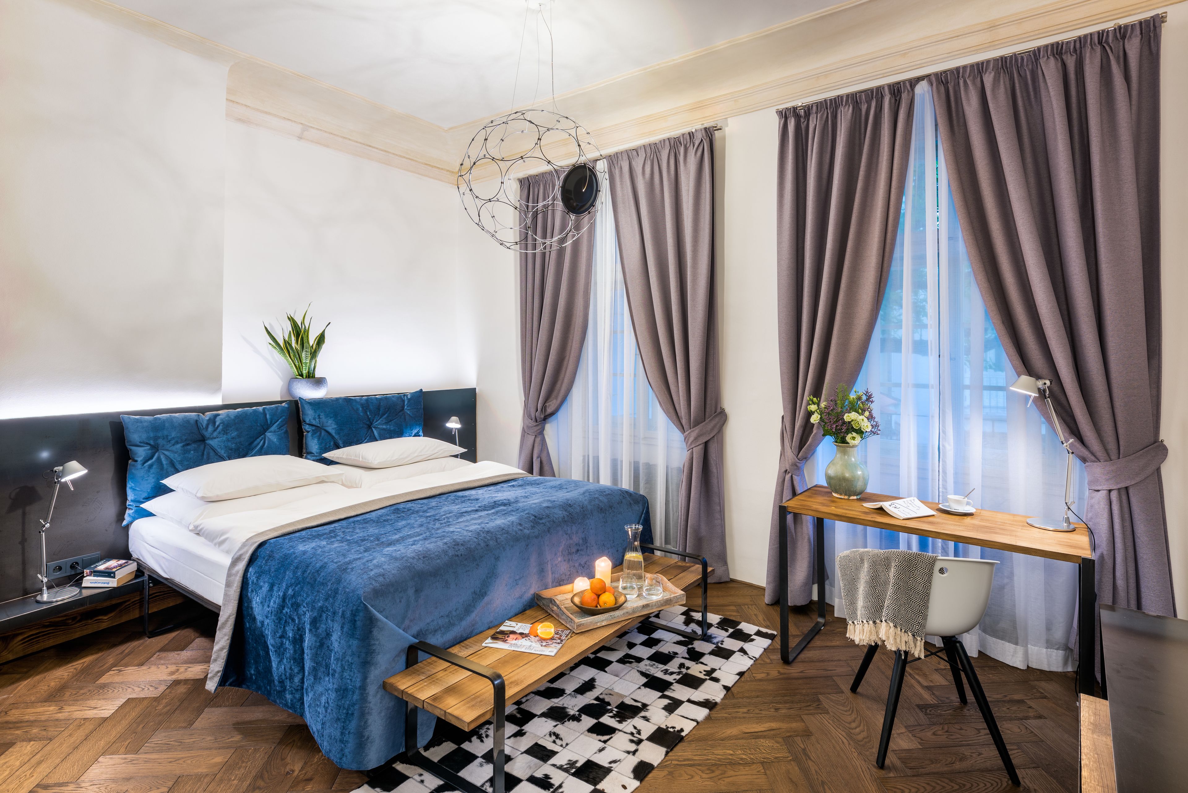 Een moderne slaapkamer met een groot bed, een bureau en een stoel.