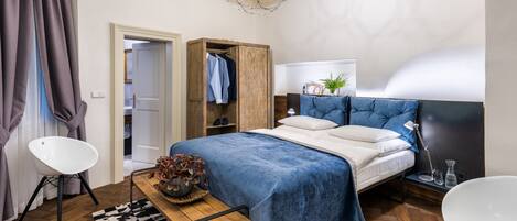 A modern bedroom with a bed, a wooden wardrobe, a desk, and a chair.