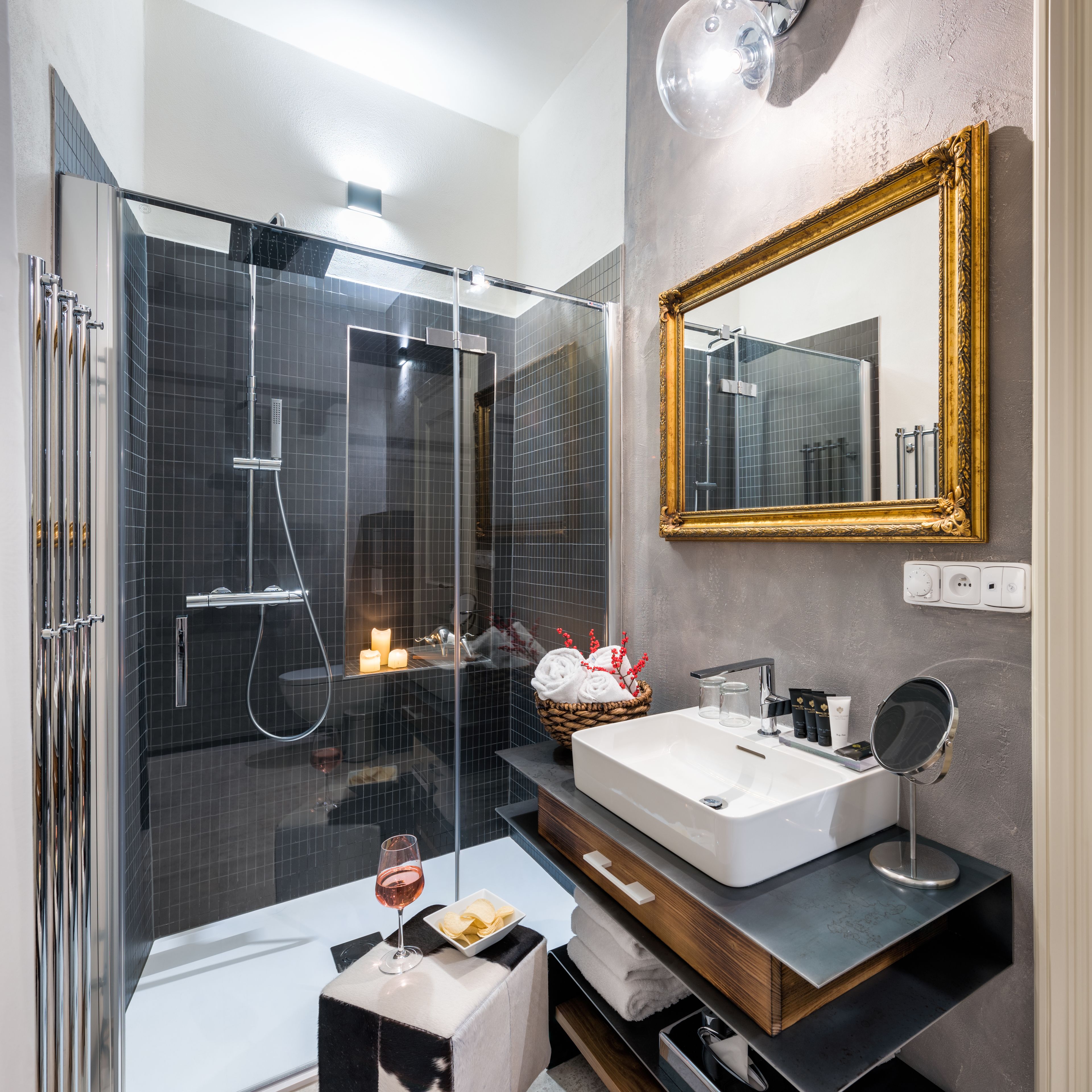 A modern bathroom with a glass-enclosed shower, a large mirror, and a vanity with a sink and towel rack.