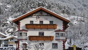 A two-story building with a sign reading "Bauser Apartments" and a balcony.