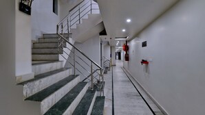 A clean, modern hallway with marble steps and a metal railing. - Hotel Noida International (Noida)