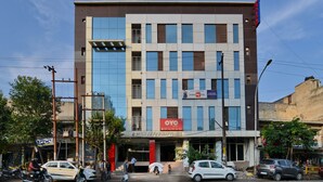 A modern hotel building with multiple floors, large windows, and a prominent sign for OYO rooms. - Hotel Noida International (Noida)