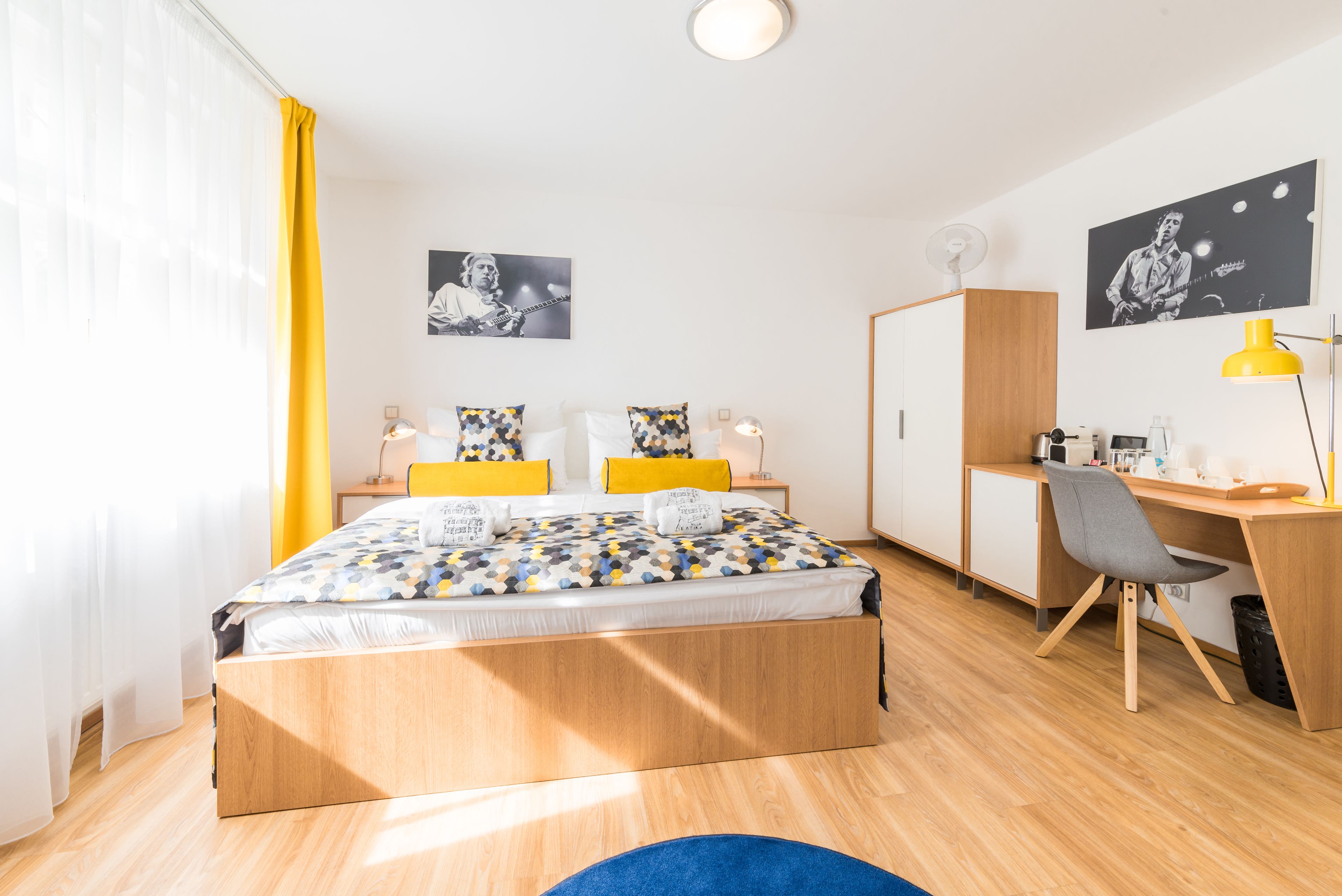 Een moderne slaapkamer met een houten bed, een bureau en een stoel.